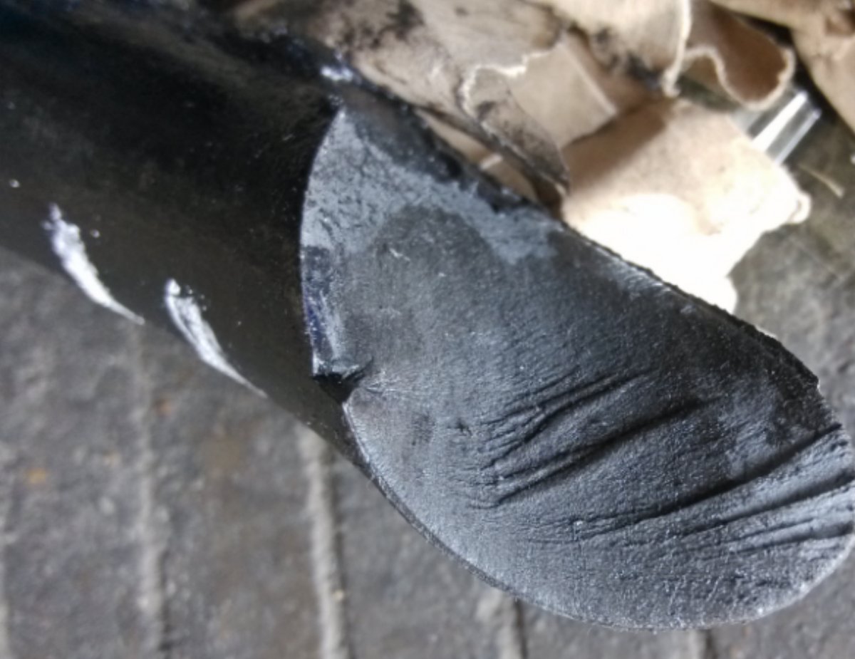 Close-up of spring fatigue fracture surface — beach marks and striations visible under magnification, classic indicators of progressive crack growth